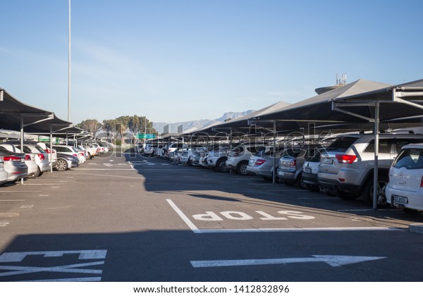 Cape Town\
International Airport - May 29, 2019: rows and rows of parked cars\
or vehicles in parking bays at the shade undercover car park in the\
vicinity of the terminal\
buildings