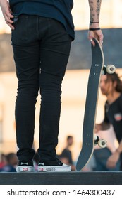 Cape Town - July 09, 2019:  Rear Or Back Of Male Skate Boarder Standing On A Wall Dressed In Jeans And Holding A Skate Board Wearing Vans Off The Wall Independent Black And White Footwear Or Shoes