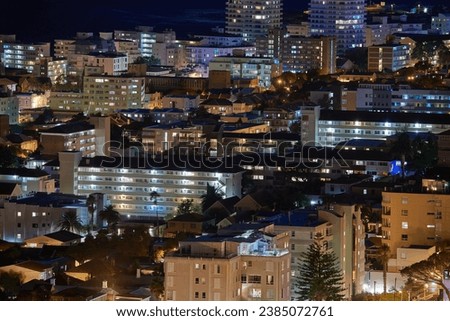 Cape Town at night. Aerial view of urban construction in the evening. The landscape of an electrically lit up town at nighttime. Night cityscape of the beautiful city of Cape Town in South Africa.