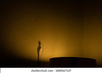 Cape Town, South Africa - 05/20/20

Paper Doll Man, Standing On Top Of A Lamp Shade, Staring Into The Bright Yellow Light. Appearing Lonely And Melancholic, But Focusing On The Light.