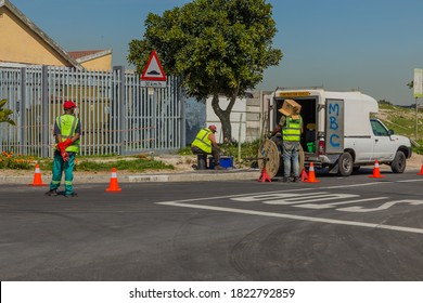 Cape Town, South Africa - 07 September 2020: Council Worker, Road Works, Laying New Fiber Cables Into The Ground, Wearing A Cardboard Box As A Hat To Protect Against African Heatwave.