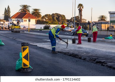 Cape Town, South Africa - August 2020: South African Construction Workers Laying New Road Down. Protective Masks For Corona Virus Pandemic, Covid 19. PPE. City Workers.