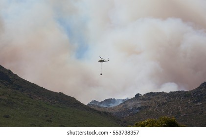 CAPE TOWN, SOUTH AFRICA - JAN 11 2017. Helicopters Being Used To Collect Water From A Local Lake To Fight Wild Fire In The Mountains Behind The Glencairn Suburb Of Cape Town.