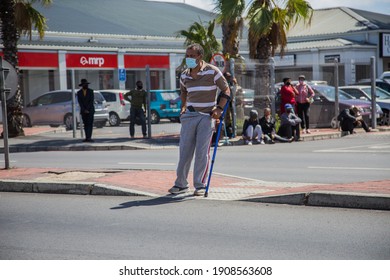 Cape Town, South Africa - January 2021: Disabled Mixed Race South African Man Crossing Busy Street In Traffic, Wearing A Face Mask To Prevent Covid 19. Corona Virus In Africa. Unemployment In Africa.