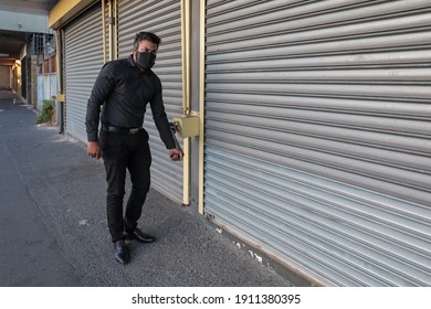 Cape Town, South Africa - January 2021: Mixed Race Businessman, Closing Business Early For Corona Virus Lockdown Curfew, Wearing Face Mask To Protect Himself From Covid 19 Pandemic In Africa.