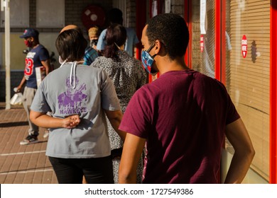 Cape Town, South Africa - May, 2020: People Wearing Face Masks Stand In Line For Shopping Mall During Corona Virus Pandemic Lock Down.