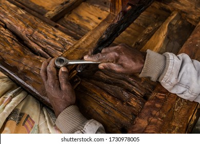 Cape Town, South Africa - May 2020: Old African Man carpenter making wooden table wearing face mask during Corona Virus Pandemic in Africa