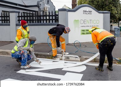 Cape Town, South Africa - May 2020: Traffic Line Workers Painting New Lines At Stop Street Sign. Maintenance And City Upgrade. Economic Development In Africa. Protective Masks Corona Virus Pandemic