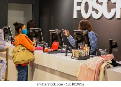 Cape Town, South Africa - November 2020: Mixed Race Woman Shopping During Corona Virus Pandemic In Africa. Retail Shop Assistant Wearing Face Mask For Covid 19 Protection.