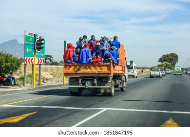 Cape Town, South Africa - November 2020: African Migrant Workers Transported Of The Back Of Dump Truck, Packed Together With Face Masks During Covid 19 Corona Virus Pandemic In Africa.  