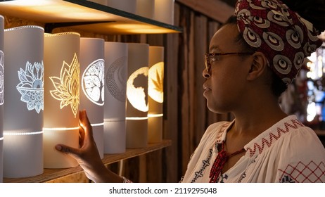 Cape Town, South Africa - November 2021: A Local African Crafts Woman Poses With Her Hand Made Artistic Lights At A Market.