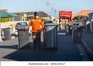 Cape Town, South Africa - October 2020: Black African Garbage Collectors Working In Africa During Covid 19 Pandemic Wearing Face Mask For Protection. Front Line Worker, Corona Virus. Garbage Truck.