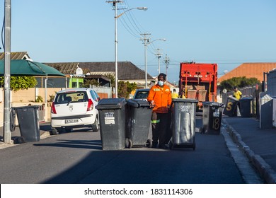 Cape Town, South Africa - October 2020: Black African Garbage Man Collection Dirt Bins In Community, Service Delivery. Front Line Worker.