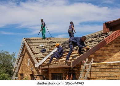 Cape Town, South Africa - October 2021: Black African Migrant Laborers Working On A New Roof In The Hot Sun. Contractors Fixing Damaged Roof.
