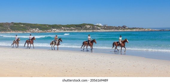 CAPE TOWN, SOUTH AFRICA - SEPTEMBER 16, 2021: A group of unidentified horse riders on Long Beach in the Cape Peninsula, South Africa.