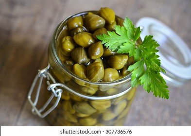 Capers In A Jar On Wooden Table.