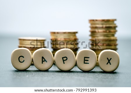 CAPEX letter block and stack coins, business concept. CAPEX stands for Capital Expenditure.
