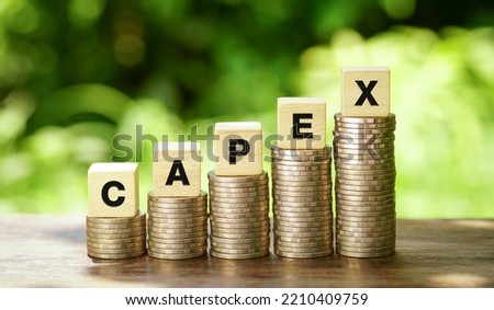 CAPEX letter blocks and stack coins, business concept. CAPEX stands for Capital Expenditure.                            