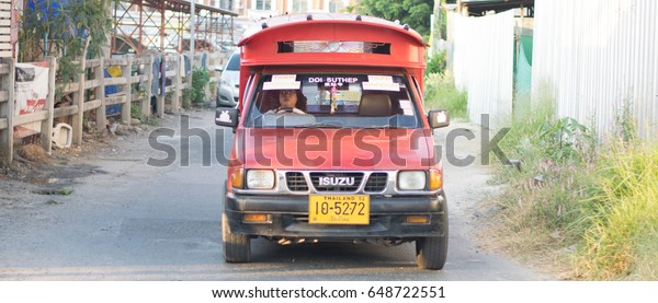 Capital District, Chiang Mai, Thailand - 11 DECEMBER\
2016 : Red taxi in format pickup trucks driving around city streets\
and are the vehicle of choice locals use to get around Chiang\
Mai.