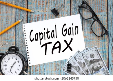 Capital Gain Tax. Text On White Paper On Wooden Blue Background Business Concept