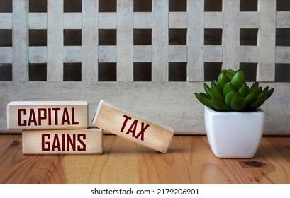 CAPITAL GAINS TAX - Words On Wooden Blocks On A Beautiful Background. Business And Hybrid Work Culture Concept, Copy Space.