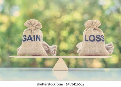 Capital investment gain and loss, financial concept : Gain and loss bags on a basic balance scale, depicts balancing between profit and loss while managing assets e.g bonds, stocks, derivatives, ETFs - Shutterstock ID 1433416652