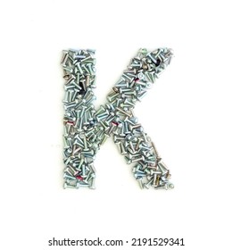 Capital Letter K Made From Screws And Bolts. Alphabet Made From Used Screws. White Background. Industrial Bolt Font