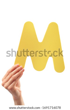 Capital letter M held in woman's hand on white background Stock fotó © 