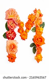 Capital letter M made with red orange roses, isolated on white background