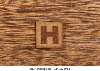 Capital Letter In Square Wooden Tiles    Letter H  On Wooden Background 