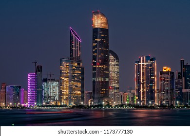 The capital of UAE, Abu Dhabi, light up in colors at night. Luxury travel holiday inspiration. City skyline view. 
