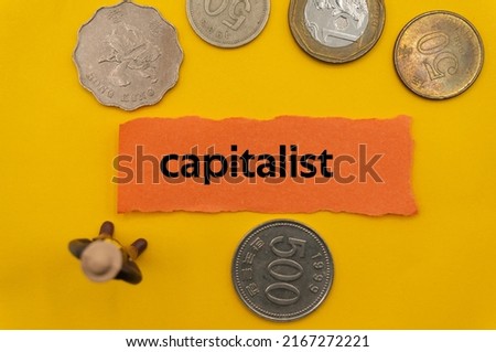 capitalist.The word is written on a slip of paper,on colored background. professional terms of finance, business words, economic phrases. concept of economy.