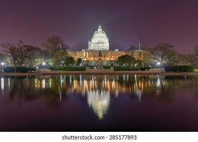 The Capitol Building of the United States of America at night. Seen with the dome under construction reflecting in the reflecting pool.