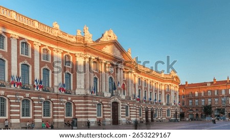 The Capitole de Toulouse timelapse hyperlapse showcases historic city hall and municipal heart of Toulouse, France, located at Place du Capitole under a blue sky. Shadow covering facade during sunset