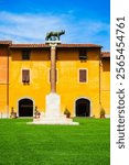 The Capitoline Wolf or Lupa Capitolina is a bronze sculpture near the Pisa Leaning Tower at Piazza dei Miracoli or Square of Miracles in Pisa, Italy