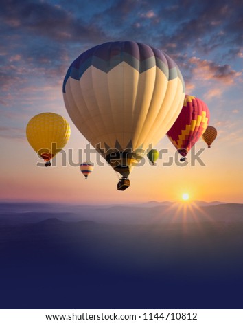 Cappadocia at sunrise - landscape with hot air balloons flying over mountain valley in sunlight and mist. Vertical billboard with place for text bottom for ballooning festival or travel background.