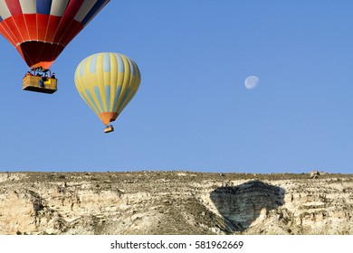 CAPPADOCIA, TURKEY - MAY 18, 2014: Hot air balloons in the sky with the moon in Cappadocia, Turkey
