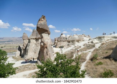 CAPPADOCIA, TURKEY - SEP 11, 2019 - Tourists explore fairy chimney balanced rock formations near Devrent, Pasabaglari, Cappadocia, Turkey