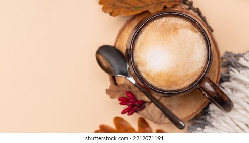 Cappuccino Coffee In A Ceramic Cup, Top View. Milk Foam, Texture. Cappuccino On An Autumn Background With Foliage On A Beige Background With Copy Space.