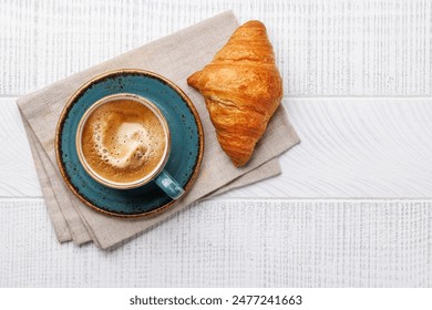 Cappuccino coffee and fresh croissant on wooden table. Flat lay with copy space - Powered by Shutterstock