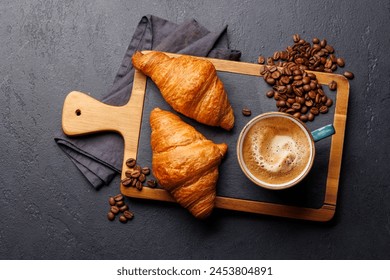 Cappuccino coffee and fresh croissants on stone table. Flat lay