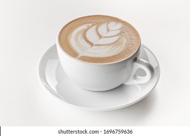 Cappuccino coffee with latte art on top in white ceramic mug. White background.