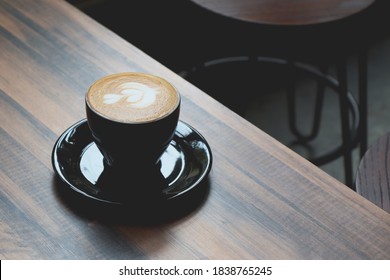 Cappuccino or coffee latte on wooden table with blank space for text, morning motivation concept