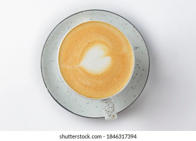 Cappuccino cup with heart shaped foam. Isolated on white background. Coffe in a small white cup. Close up.
