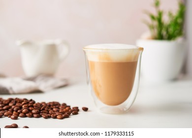 Cappuccino in a double walled glass with roasted coffee beans. Feminine rose background with copy space. High resolution image, narrow depth of field. - Powered by Shutterstock