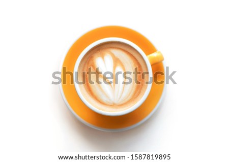 Cappuccino with frothy foam, yellow coffee cup top view closeup isolated on white background. Flat lay style.