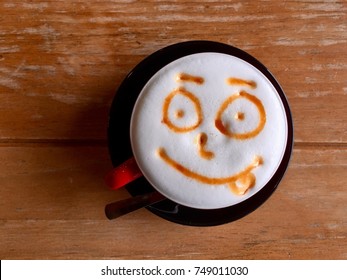 Cappuccino Latte Art With Smiley Face On Wooden Table.