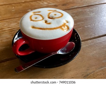 Cappuccino Latte Art With Smiley Face On Wooden Table.