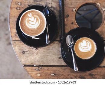 Cappuccino or piccolo coffee with heart latte art on rustic wood table top in loft cafe atmosphere. Loft style tone.