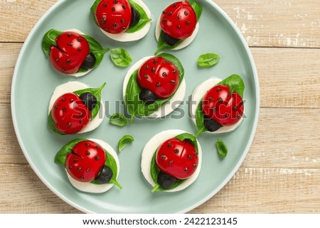 caprese ladybug tomatoes, mozzarella cheese and basil appetizers, tasty and funny food idea for Easter, top view